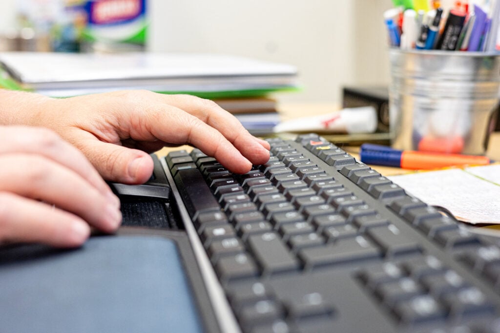 Sormet näpyttelemässä tietokoneen näppäimistöä.