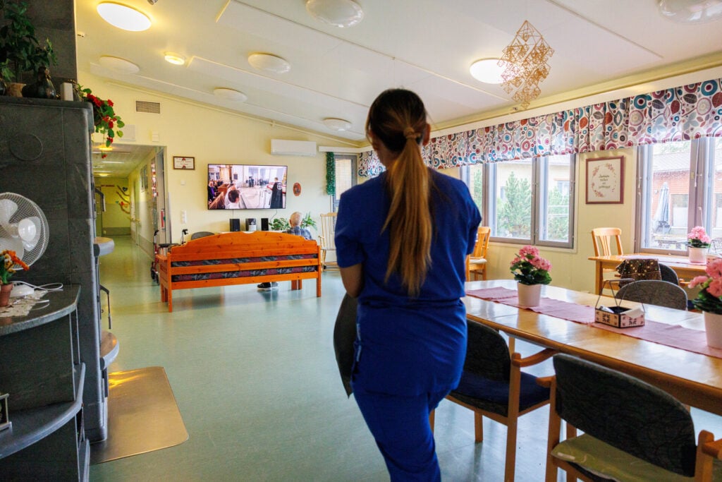 Hoitaja kävelee Koivikkolan oleskelutilassa