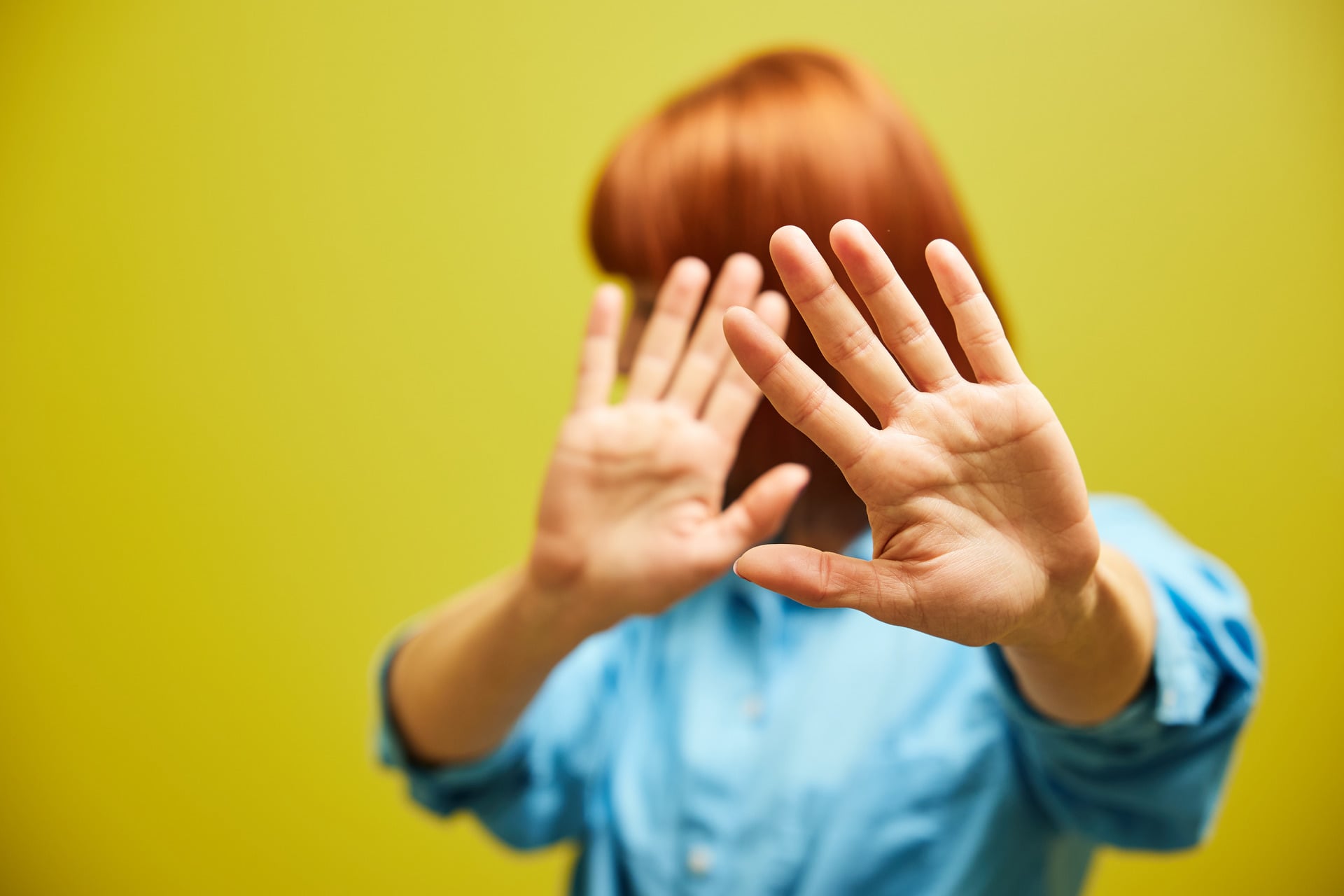 Kädet kasvojen edessä suojana.