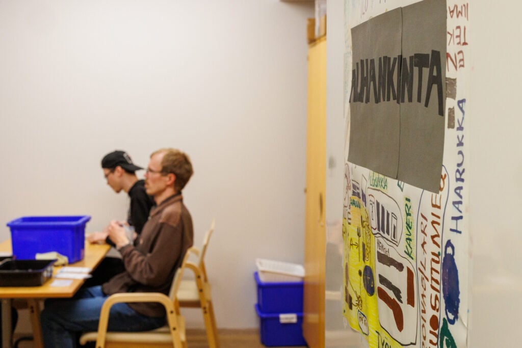 Kaksi henkilöä tekemässä alihankintatöitä pöydän ääressä.