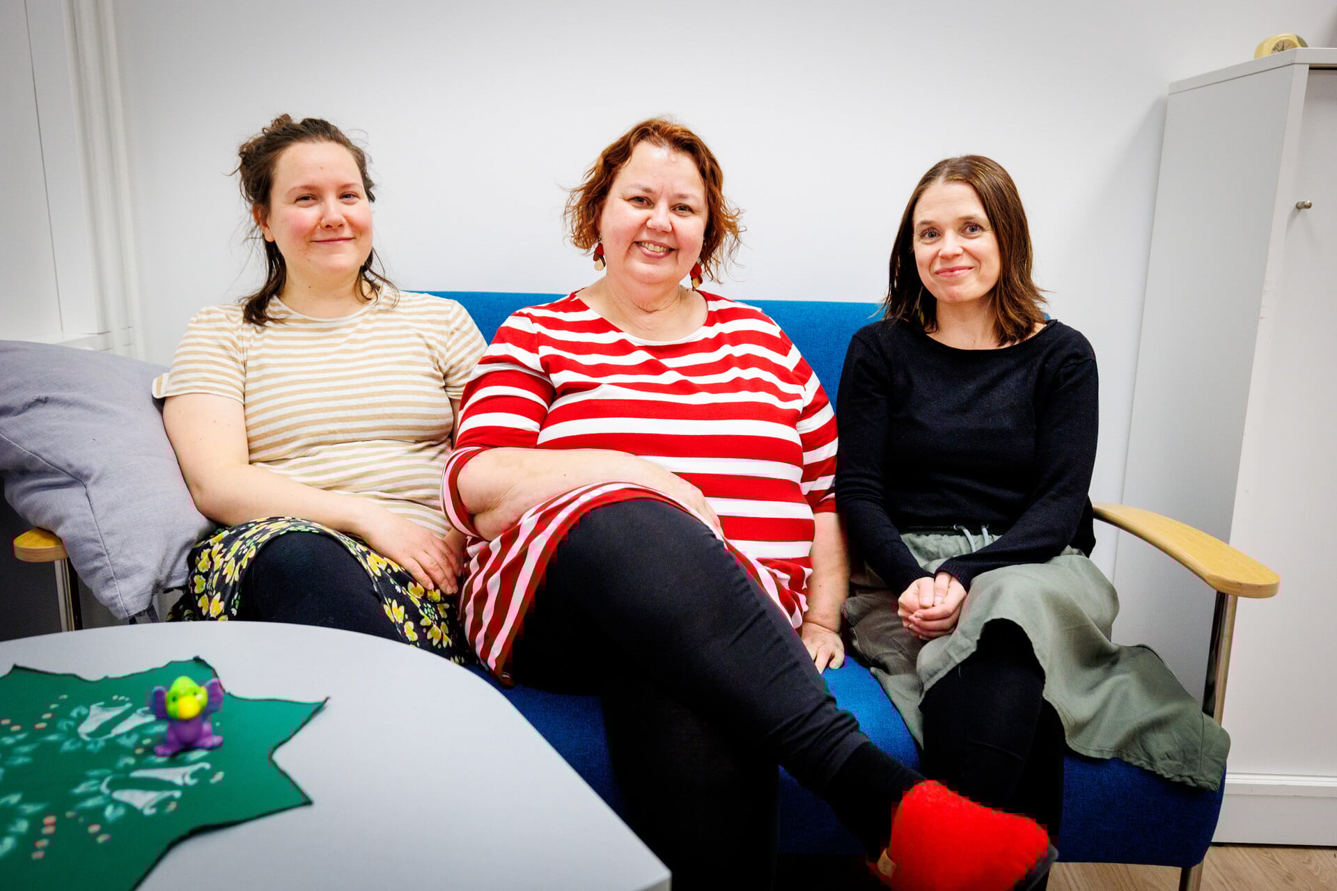 Kasvatus- ja perheneuvolan henkilökuntaa, kolme naista, istuu sohvalla