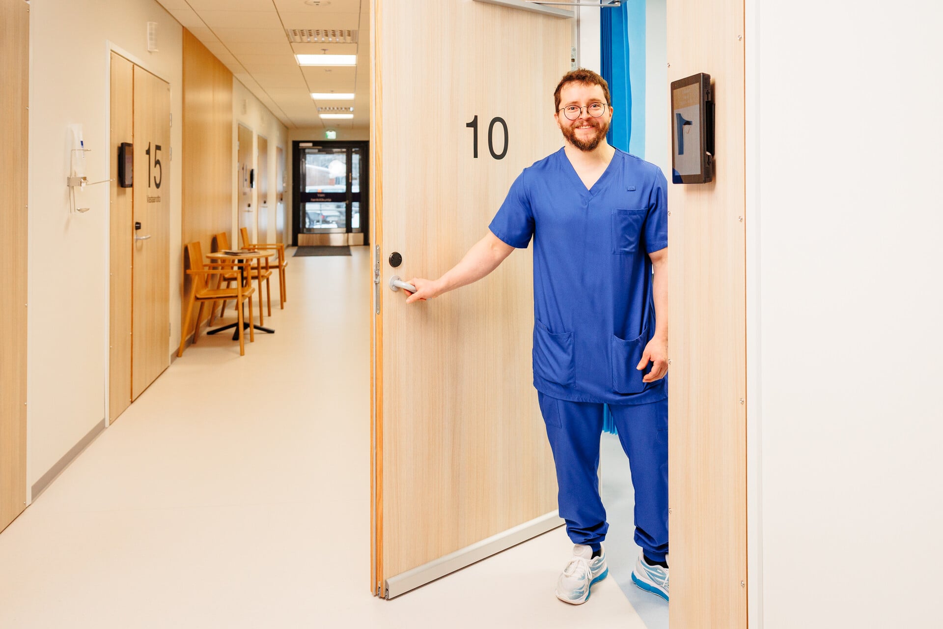 Lääkäri seisoo vastaanottohuoneen ovella